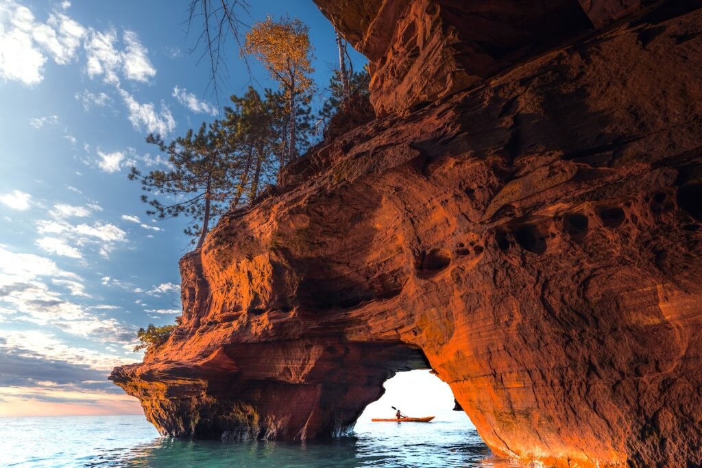 A lone kayaker exits a sea cave on The Apostle Island National Lakeshore in Wisconsin in Fall. North American destinations