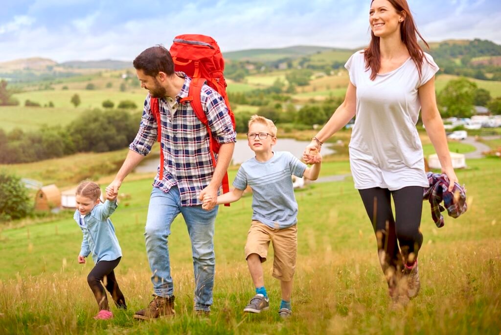 young family walking down to their campsite from the hill Discover More With Less Hassle: Ultimate Travel Itinerary You Need