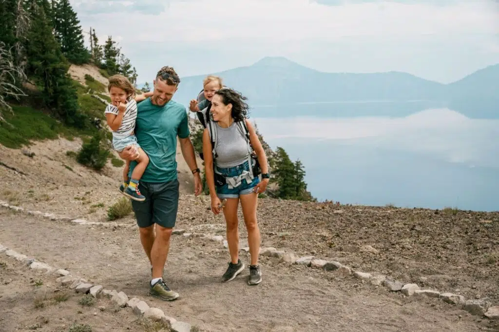 Family with young kids hiking a trail at a scenic US lake &mdash; hidden family vacation spots USA