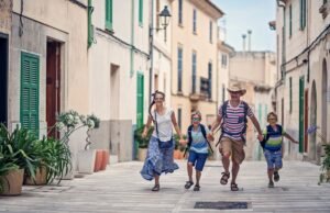 Family with kids walking through a European town street — budget family vacations outside the USA