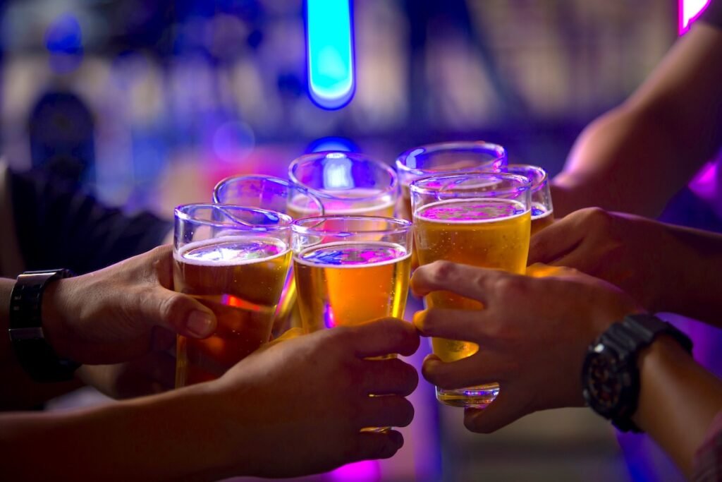 Group of  young people hands toasting and cheering aperitif beers half pint