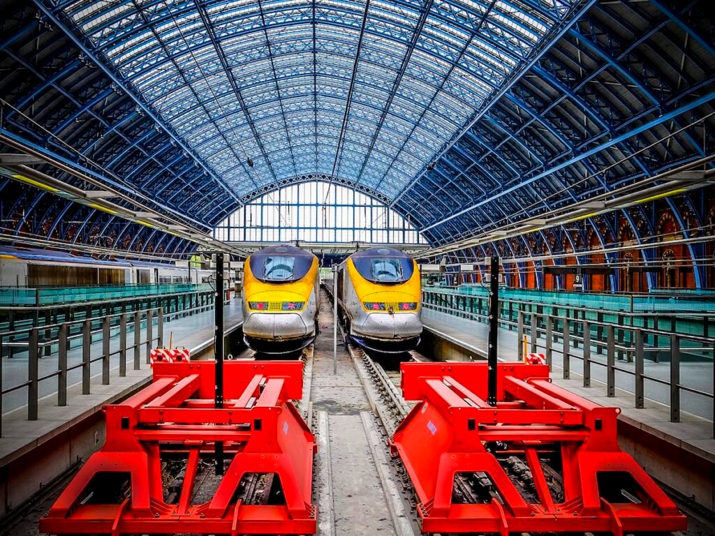 London, United Kingdom - Two huge bright red steel buffer stops protect the Eurostar terminus at St Pancras Station in London as three trains wait in platforms for their turn to take passengers on the high speed journey to Paris via the Chunnel. Opened in 1868, this masterpiece of Gothic architecture underwent a magnificent restoration completed in late 2007.