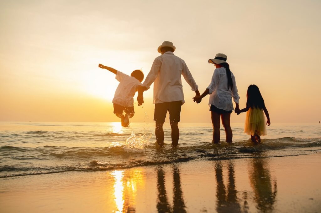 Family Vacation Ideas Happy asian family jumping together on the beach in holiday. Silhouette of the family holding hands enjoying the sunset on the beach.Happy family and vacations concept.