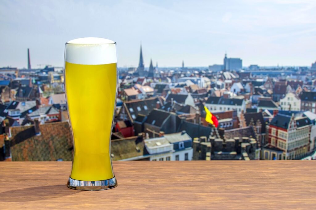 Glass of Belgium beer with view of Brussel city center during sunny day Eurostar Destinations That Make the Ultimate Romantic Getaway in 2025