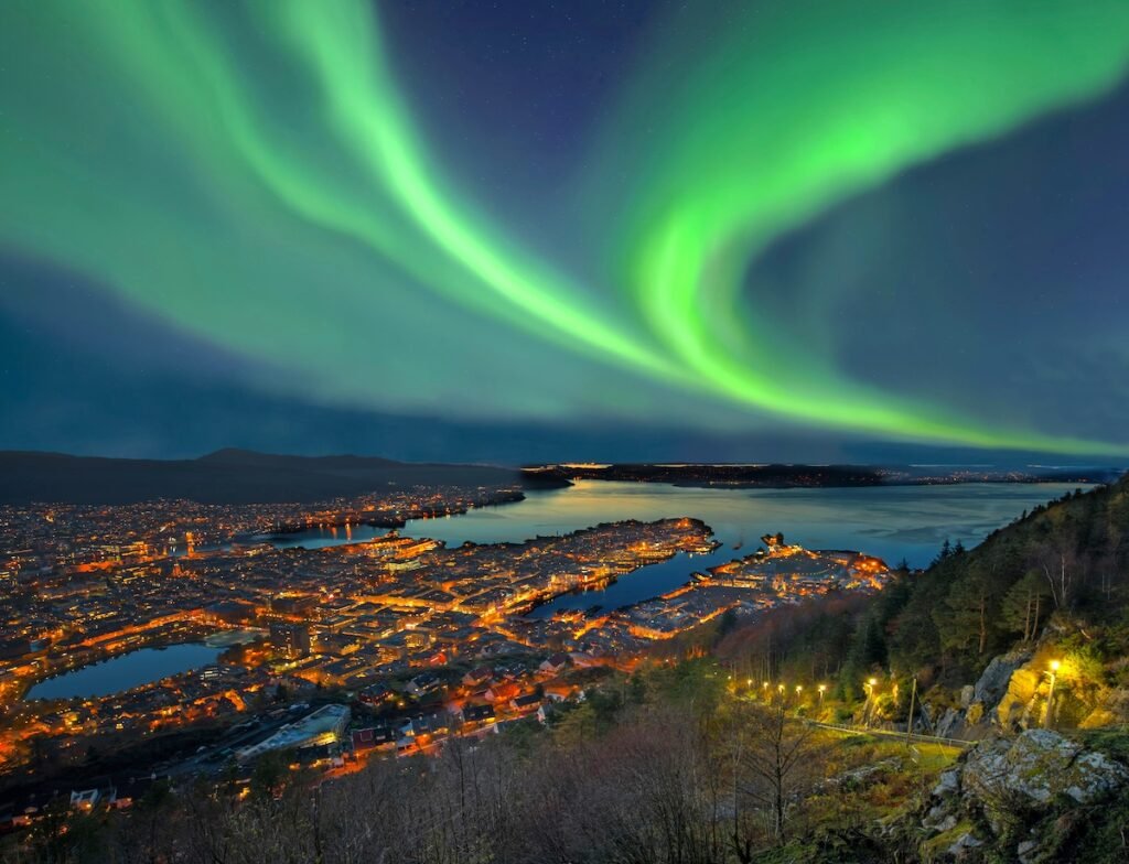 Northern lights - Aurora borealis over harbor of Bergen City, Norway. View from Floyen hill.