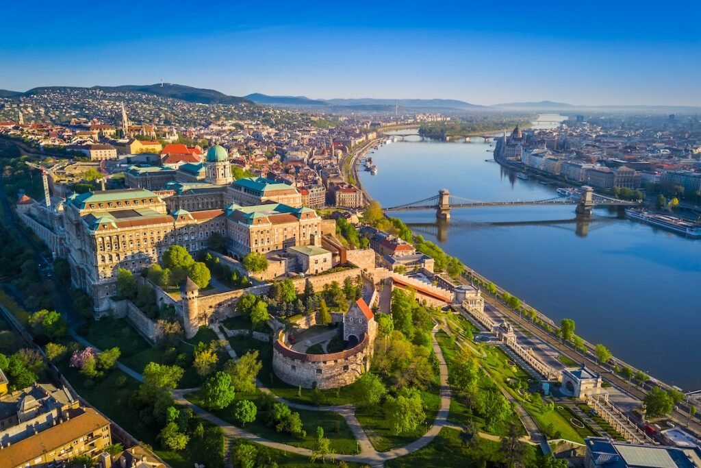 Budapest, Hungary - Beautiful aerial skyline view of Buda Castle Royal Palace and South Rondella at sunset with Szechenyi Chain Bridge over River Danube, Matthias Church and Parliament of Hungary
