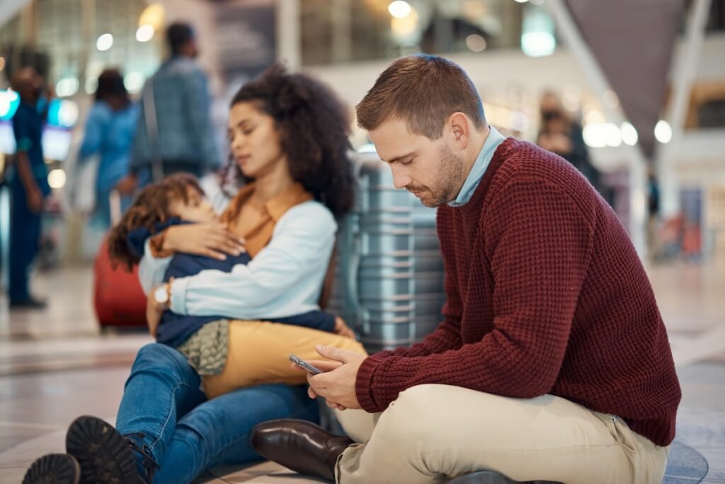 stressed dad phone airport family travel family vacation mistakes to avoid
