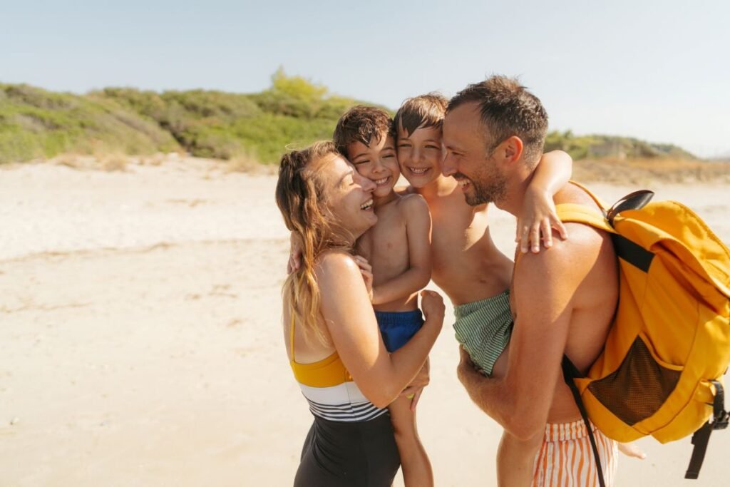Family laughing together on a European beach — budget family vacations outside the USA