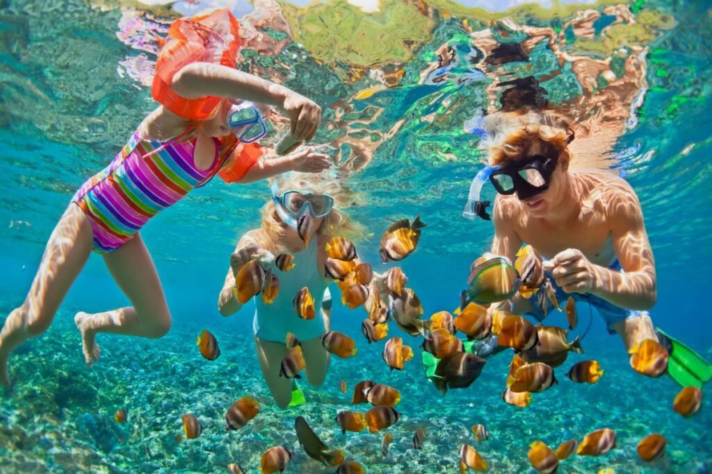 Family snorkeling with tropical fish in Caribbean waters — budget international family vacation